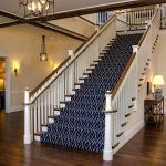 Commercial stair with custom newels posts, wood balusters, and ADA compliant railing. The custom newels are carved in the shape of lighthouses.