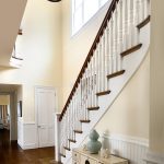 Curved stair with box newels and wood balusters. The stair features beadboard wainscoting.