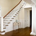 Curved stair with box newels and wood balusters. The stair features beadboard wainscoting and curves sharply at its top.