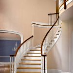 Curved stair with wood balusters and over-the-post railing.