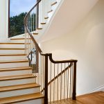 Multi-level stacked staircase with modern steel balusters and over-the-post railing.