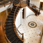 Double curved stair with wrought iron balusters in a luxury home.