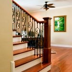 Straight stair with a box newels and wrought iron balusters.