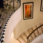 Curved stair with wrought iron balusters and stone treads and risers.