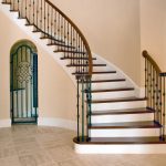 Curved stair with wrought iron balusters.