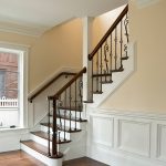 L-shaped stair with wrought iron balusters.