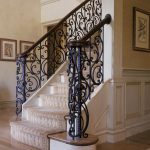 Stair with custom wrought iron balustrade and custom curved handrail. Stair flairs at bottom.