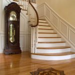 Flared stair with wood balusters and a curved handrail. Stair features paneled wainscoting.