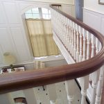 Large curved balcony with wood balusters.