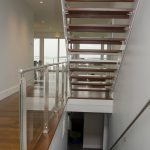 Modern stair with glass railing and open risers.