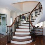 Unsupported curved stair with wrought iron balusters.