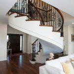 Unsupported curved stair with wrought iron balusters.